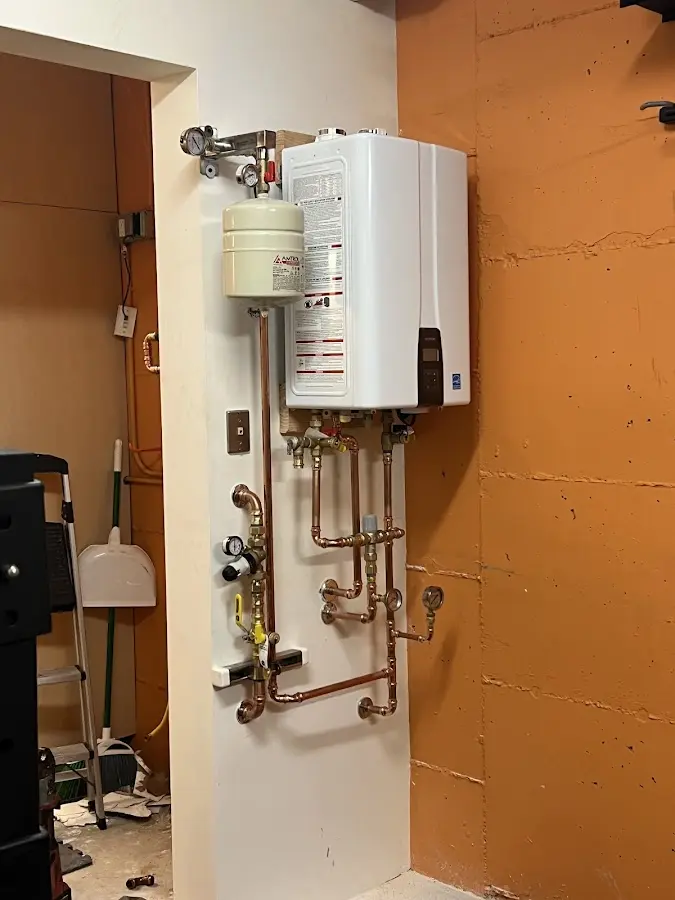 Plumbing technician inspecting water heater connections in Bismarck